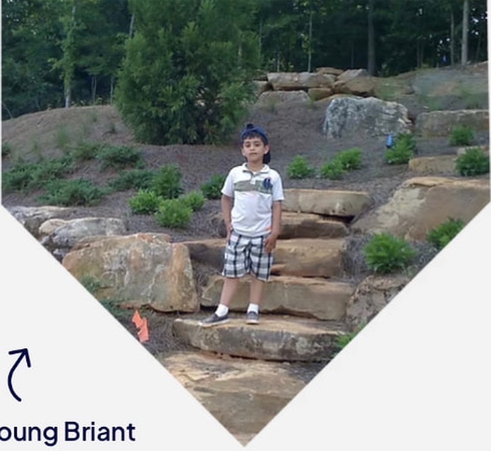 Young Briant, founder of Heredity Masonry Contractors, standing on stone garden steps